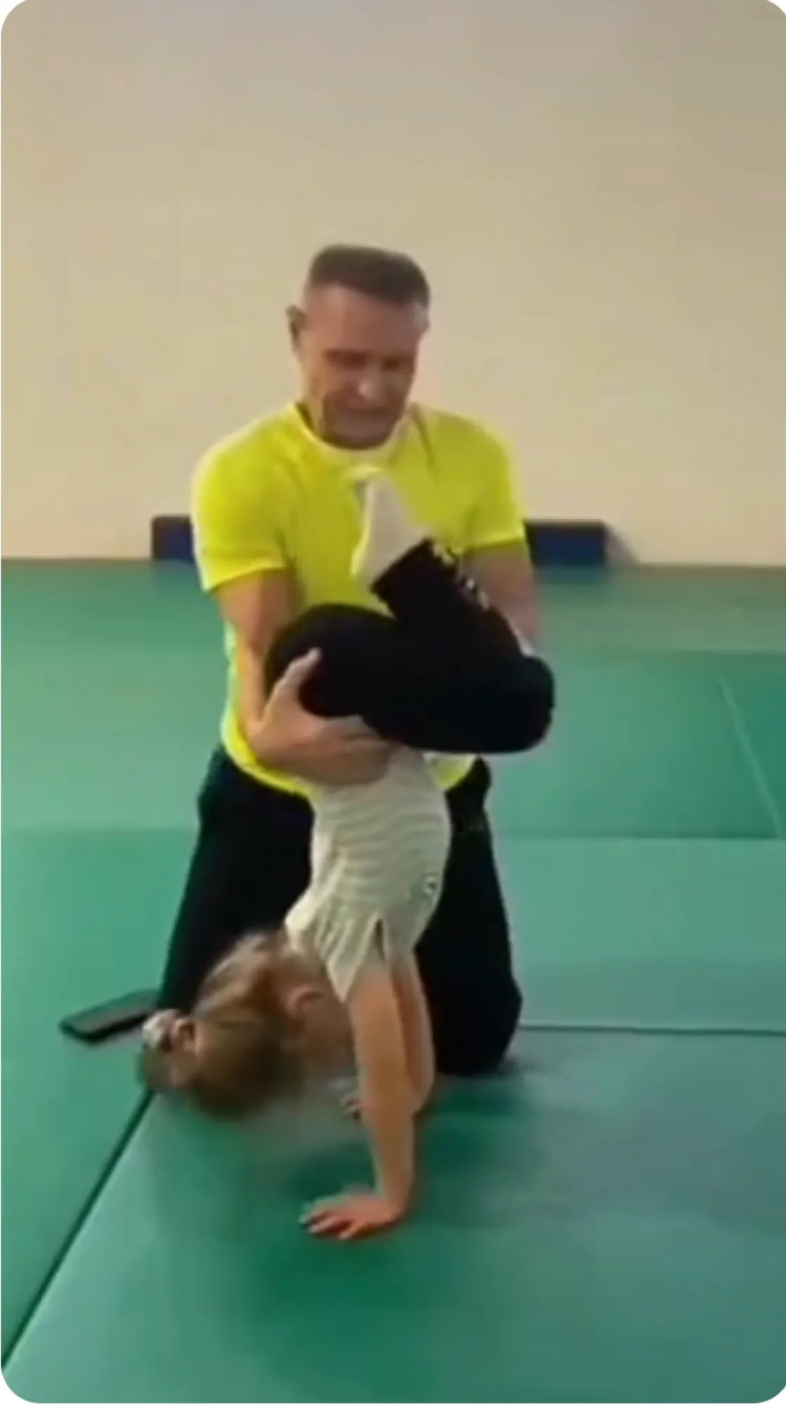 Coach spotting a child during acrobatics training